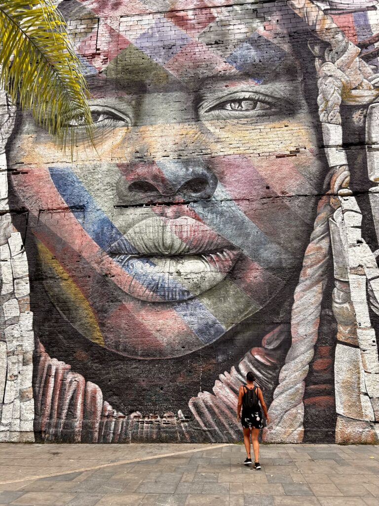 Voyageuse devant une fresque de Kobra à Rio